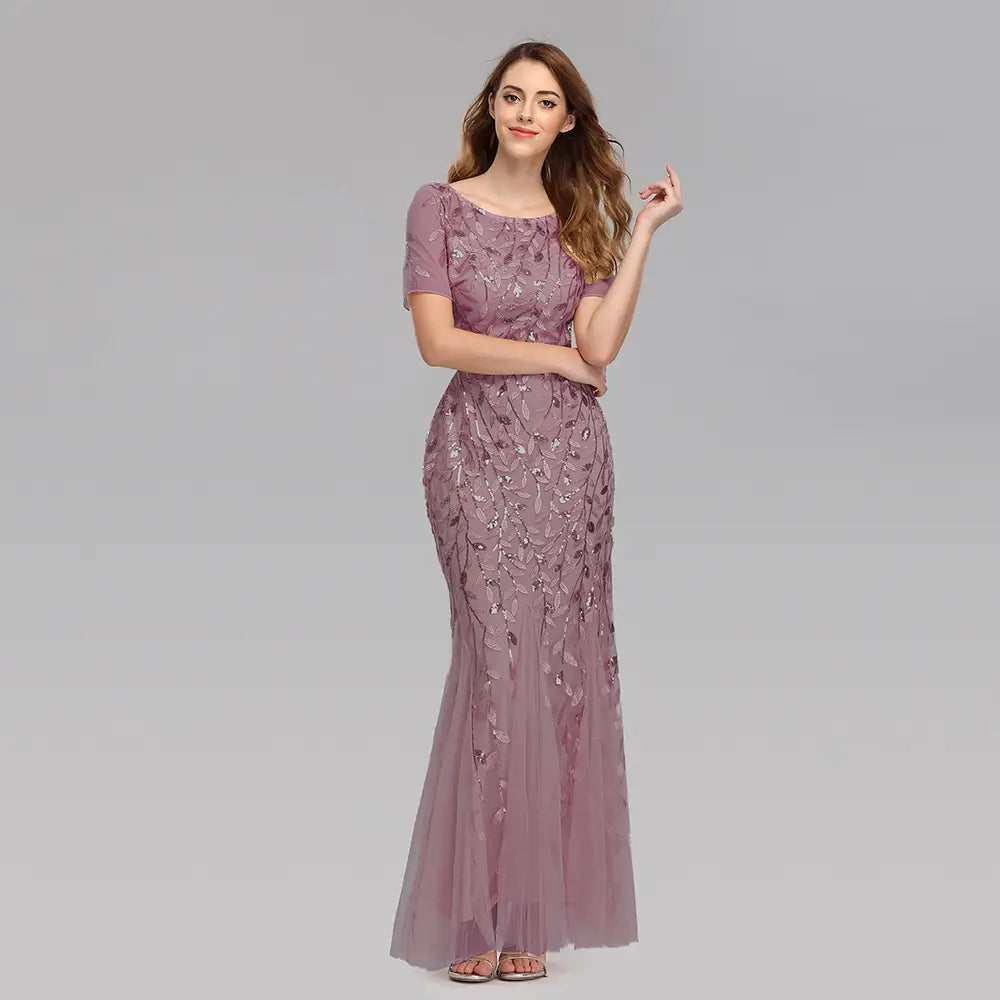 A lavender embroidered sequin mermaid evening gown with short sleeves and a fitted silhouette featuring intricate leaf-patterned metallic thread embroidery and a tulle skirt.