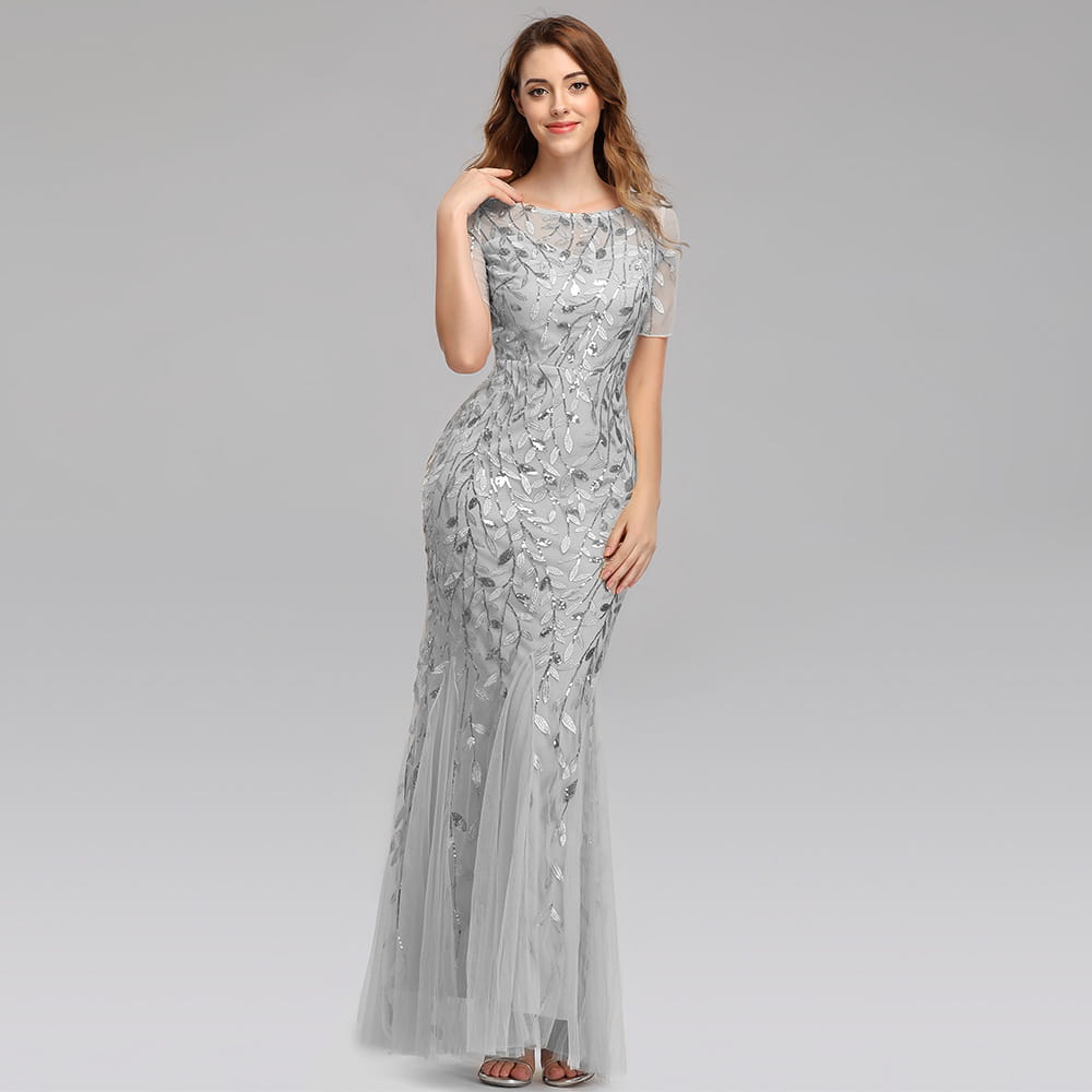 a shimmering silver embroidered sequin mermaid evening gown with intricate leaf embroidery and a flowing tulle skirt