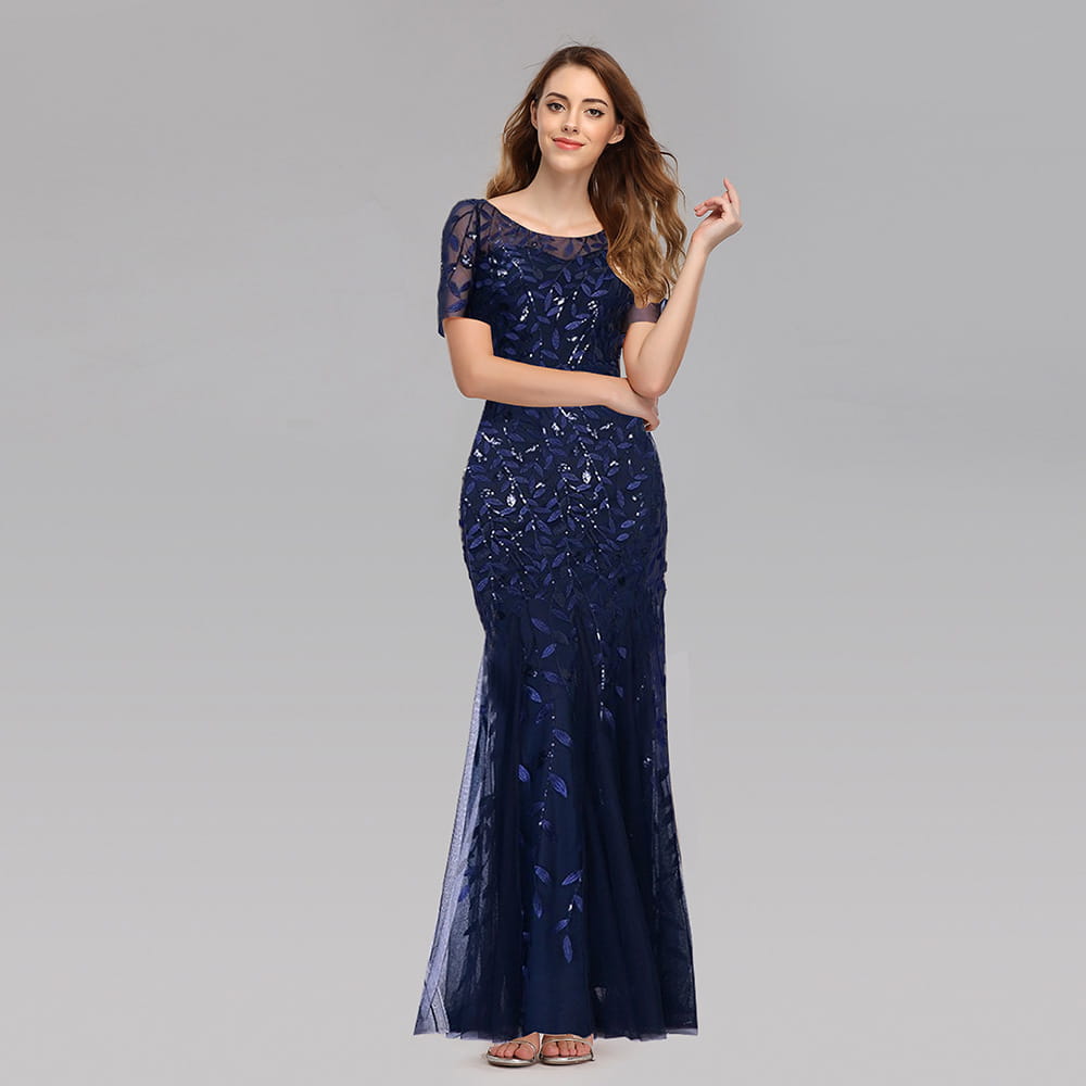 A navy blue embroidered sequin mermaid evening gown featuring intricate leaf-patterned embroidery and sheer lace sleeves with a tulle skirt.