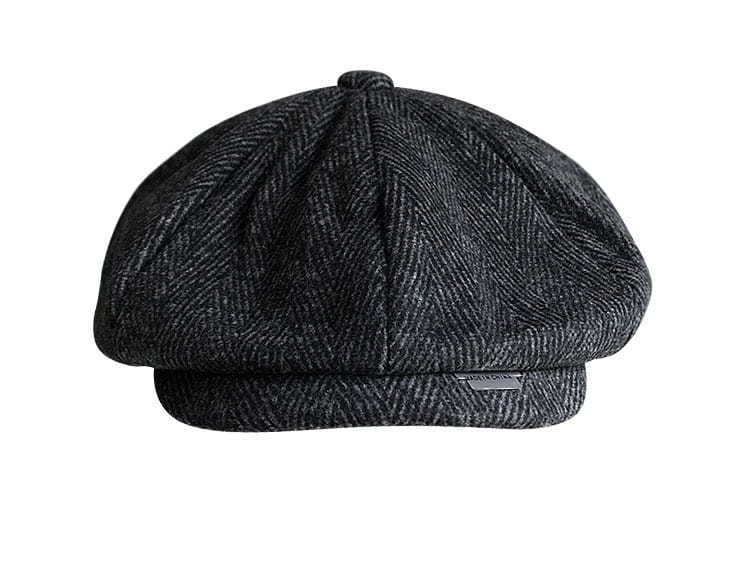 A dark gray herringbone-patterned woolen octagonal flat cap with a structured eight-panel design and a flat brim.