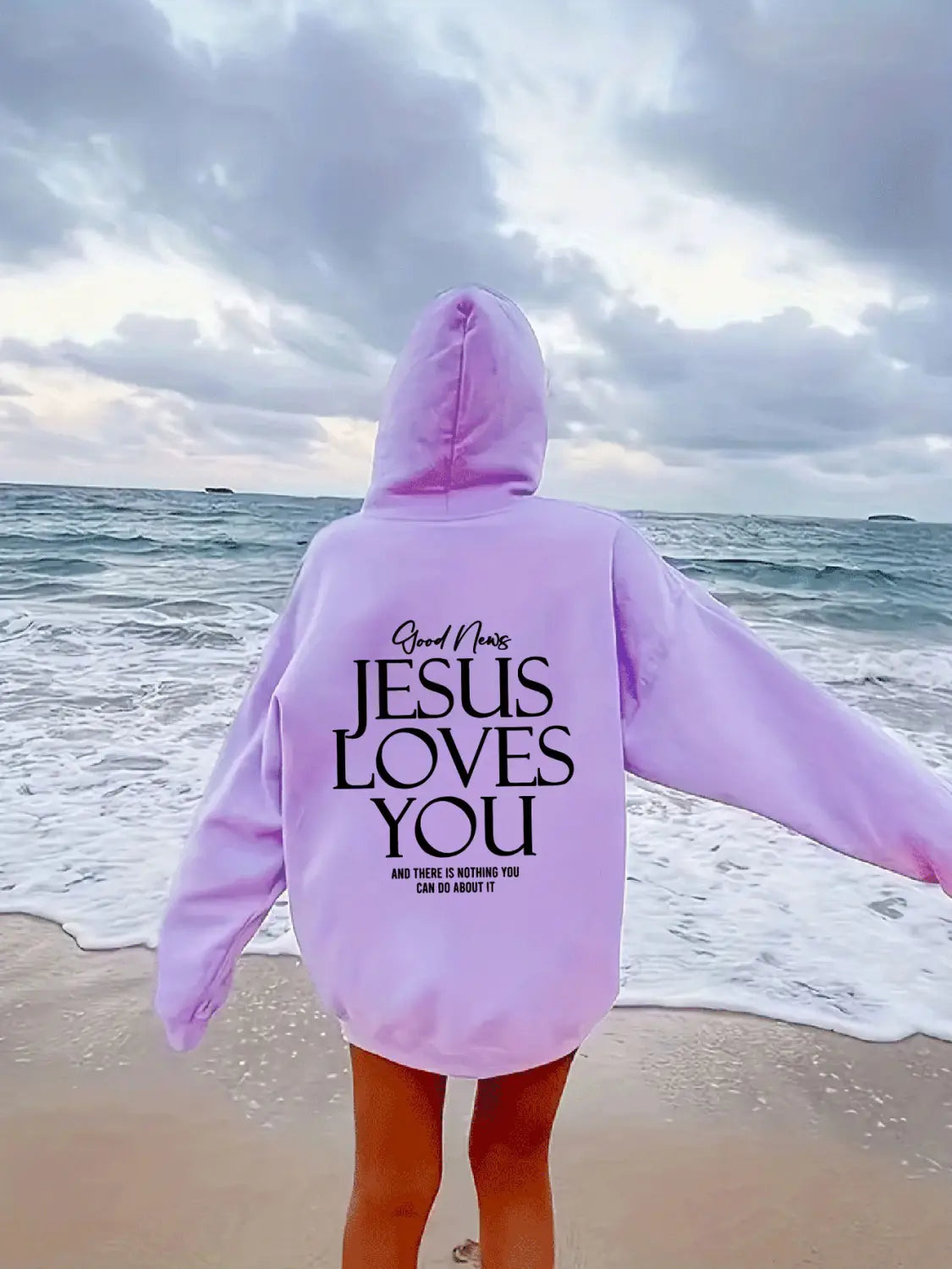 A soft lavender oversized streetwear kangaroo pocket hoodie with bold black jesus loves you text and smaller script above, featuring a relaxed fit and hood.