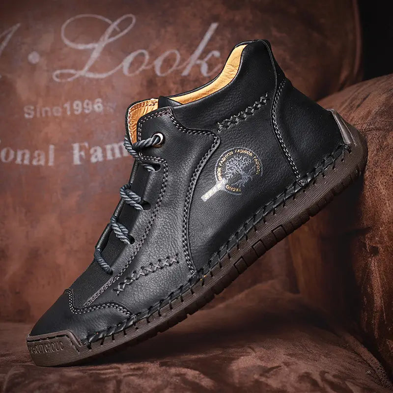 Black leather hand stitched vintage high top boot with contrasting tan lining and detailed stitching along the sole.