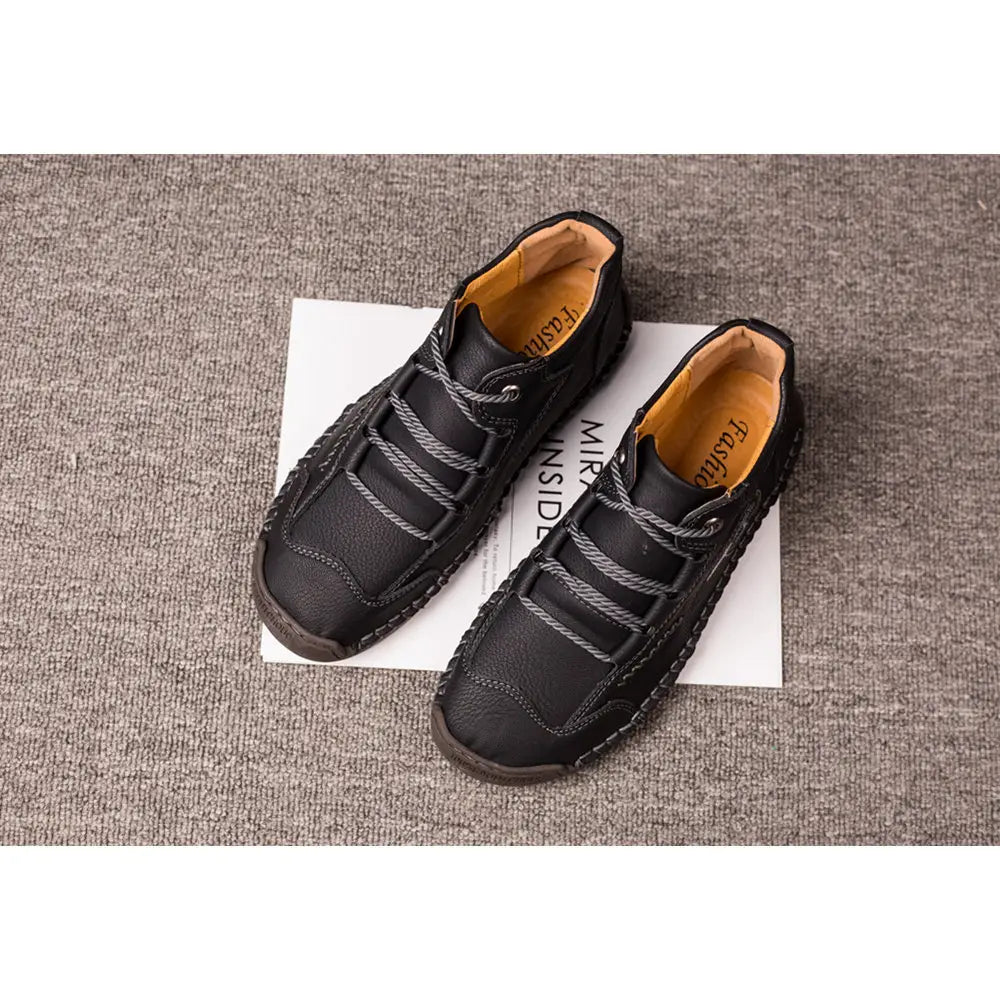 Leather boots hand stitched vintage high top sneakers in black leather with gray woven laces and tan interior lining.