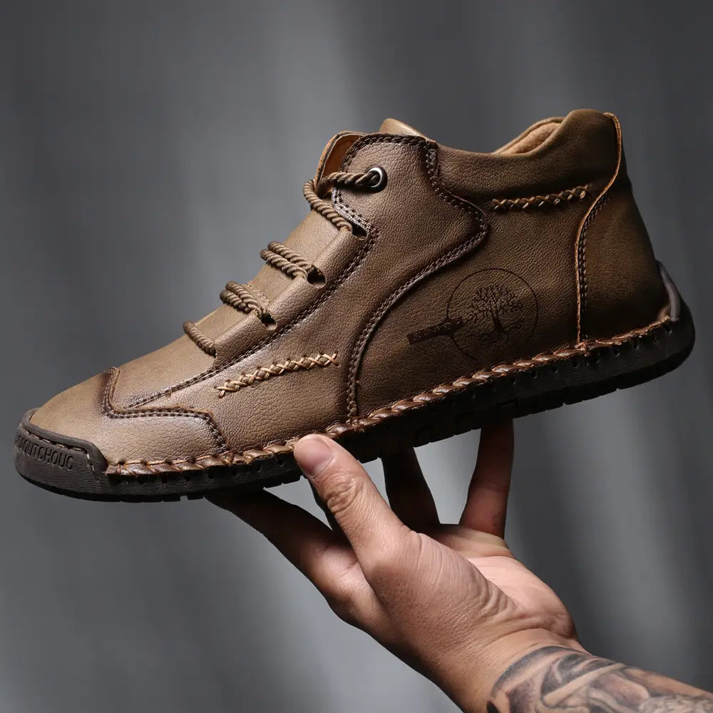 brown leather ankle boot with visible stitching and a tree emblem on the side part of leather boots hand stitched vintage high top sneakers collection