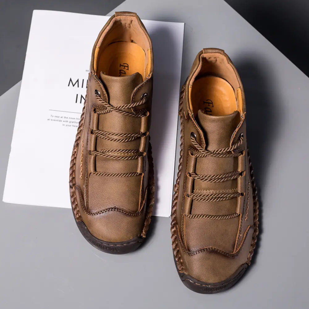 Leather boots hand stitched vintage high top sneakers in brown leather with braided rope laces and a rugged textured sole.