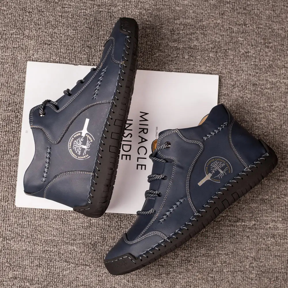Dark blue leather high-top sneakers with hand-stitched vintage detailing, contrasting black soles, and white stitching.