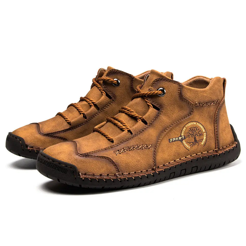 Tan leather high-top boots with brown laces and a stitched design featuring a circular logo on the side in a vintage hand stitched style.
