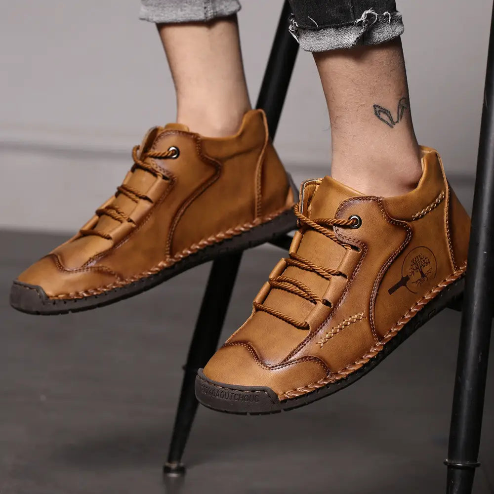 Leather boots hand stitched vintage high top sneakers in tan leather with lace-up design, visible stitching, and a tree emblem on the side.