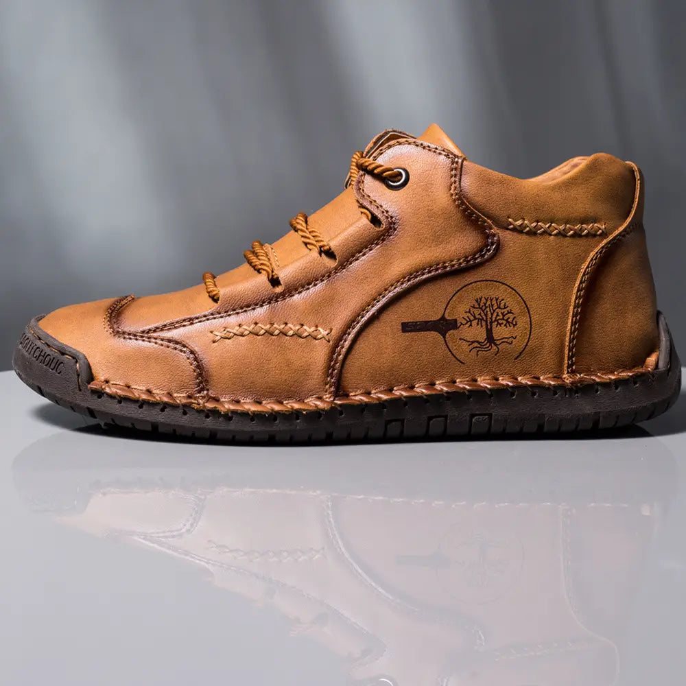Leather boots hand stitched vintage high top sneakers in tan leather with lace-up design visible stitching and tree emblem on the side.