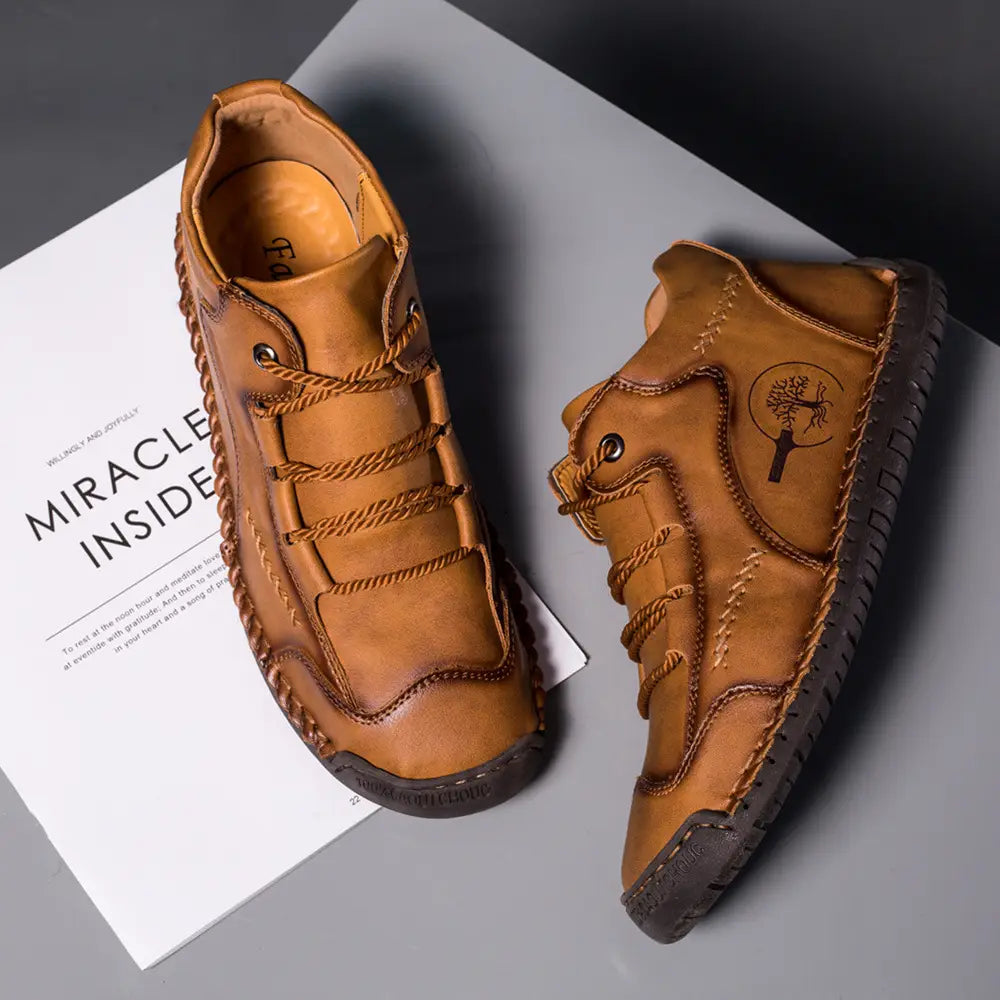 Leather boots hand stitched vintage high top sneakers in tan leather with braided laces and a tree emblem on the side.
