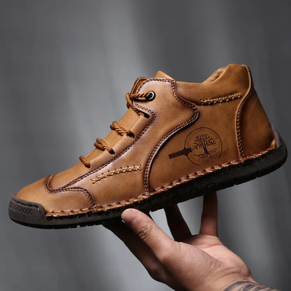 Leather boots hand stitched vintage high top sneakers featuring tan leather, lace-up design, braided stitching, and a tree emblem on the side.