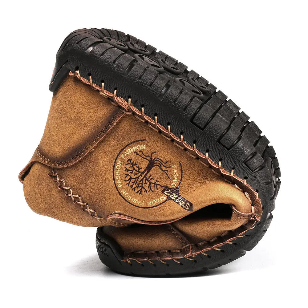 Brown leather hand stitched slip-on boots featuring a vintage high top design with a black rubber sole and visible stitching.