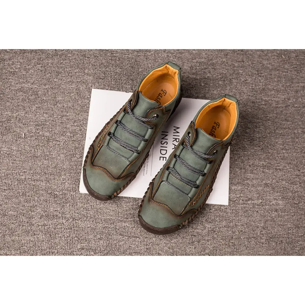 Olive green leather hand stitched vintage high top sneakers with lace-up design, contrasting orange lining, and dark brown stitching details.