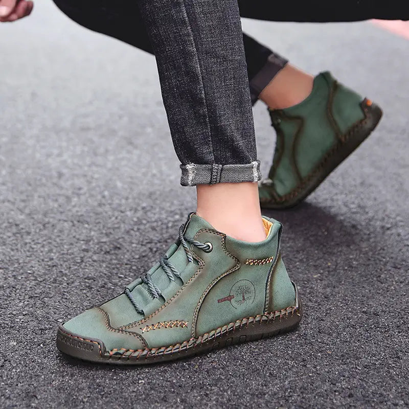 Olive green leather ankle boot with visible stitching and a small tree emblem on the side hand stitched for vintage high top sneakers style.