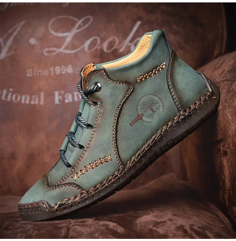 Leather boots hand stitched vintage high top sneakers featuring a moss green suede ankle boot with brown stitching a tree emblem on the side and dark laces.