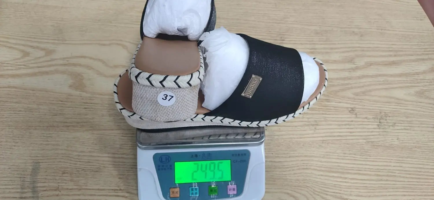 black and beige espadrille wedge sandals with woven rope sole, zigzag stitching, denim and metal accents, and a small gold-colored brand tag on the side