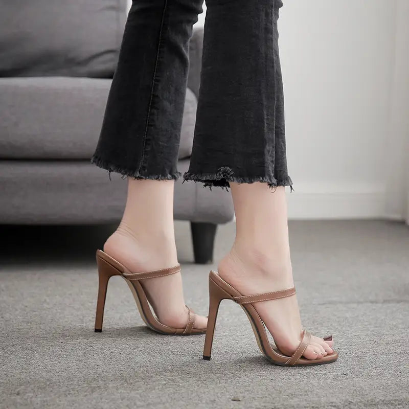 Brown leather strap mules with a high stiletto heel in a minimalist strappy high heels design.