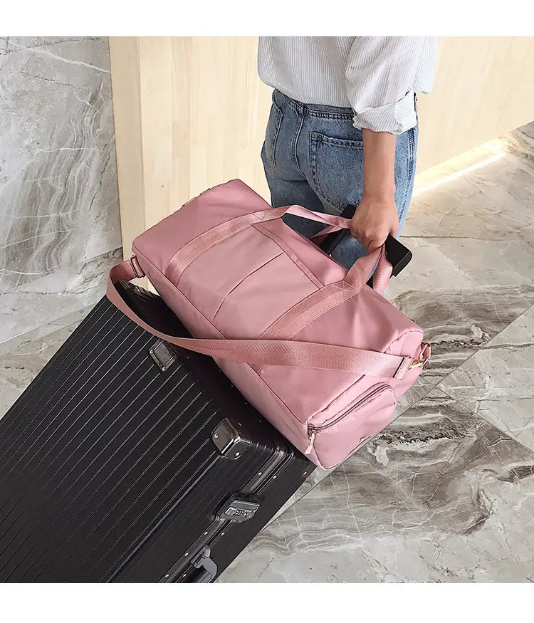 Rose gold nylon waterproof sports duffel bag in pink with adjustable shoulder strap and multiple exterior pockets.