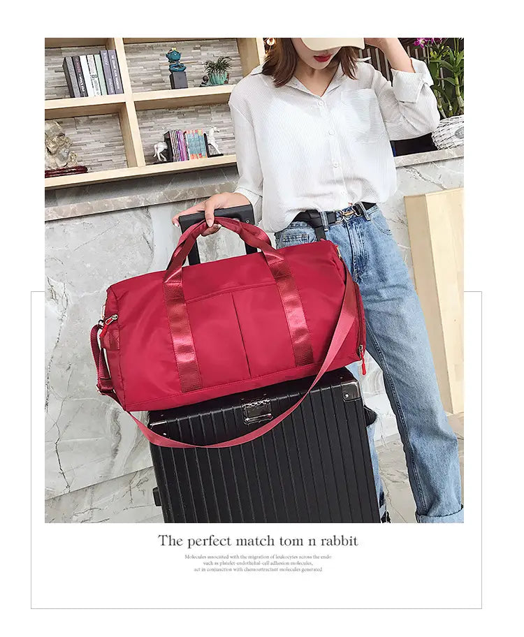 Rose gold nylon waterproof sports duffel bag featuring red nylon material with matching satin-like straps and a retractable handle.