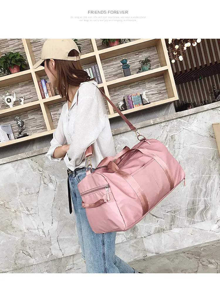 Pink nylon waterproof sports duffel bag with rose gold brown straps and zippers.