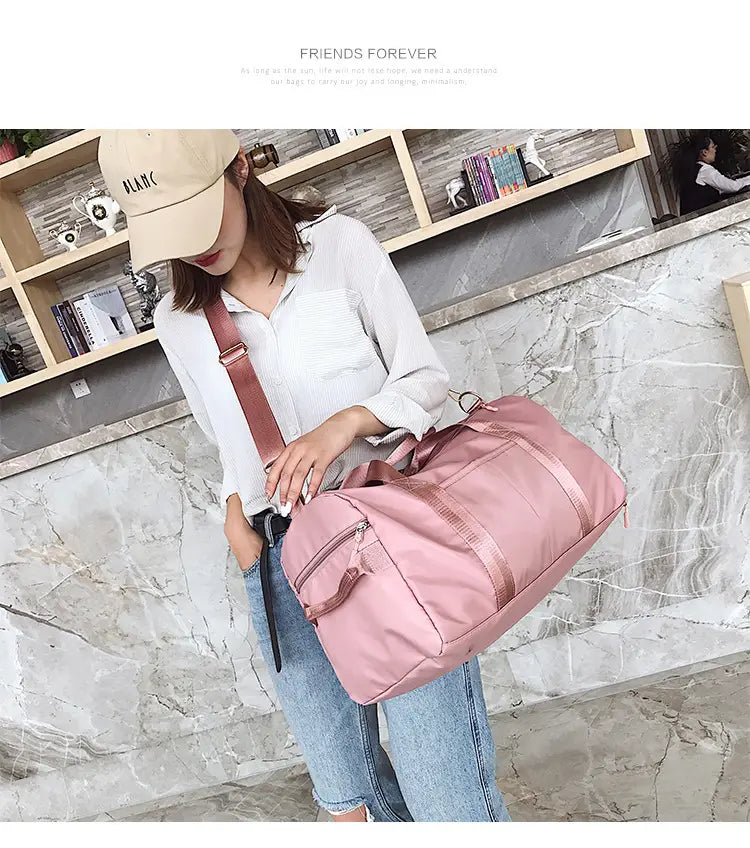 Rose gold nylon waterproof sports duffel bag in pink with matching shoulder strap and zipper details.