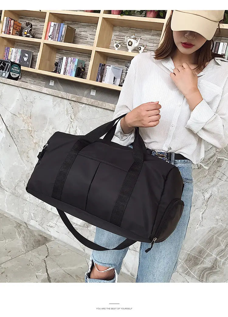Black nylon sports duffel bag with reinforced straps and zipper closure designed for durability and practicality.