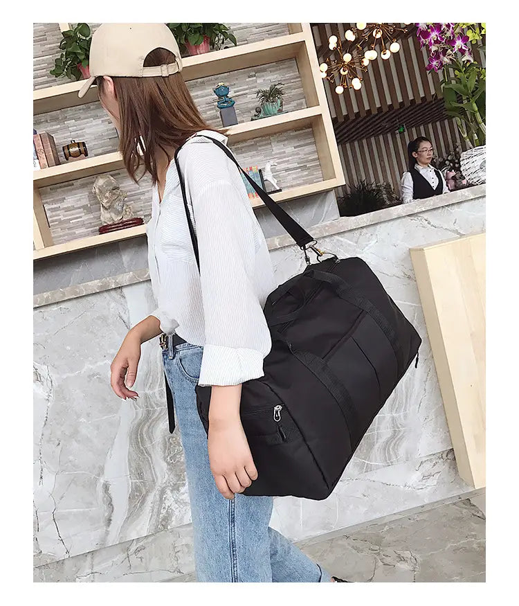 Black nylon waterproof sports duffel bag with multiple zippered compartments and a single shoulder strap.