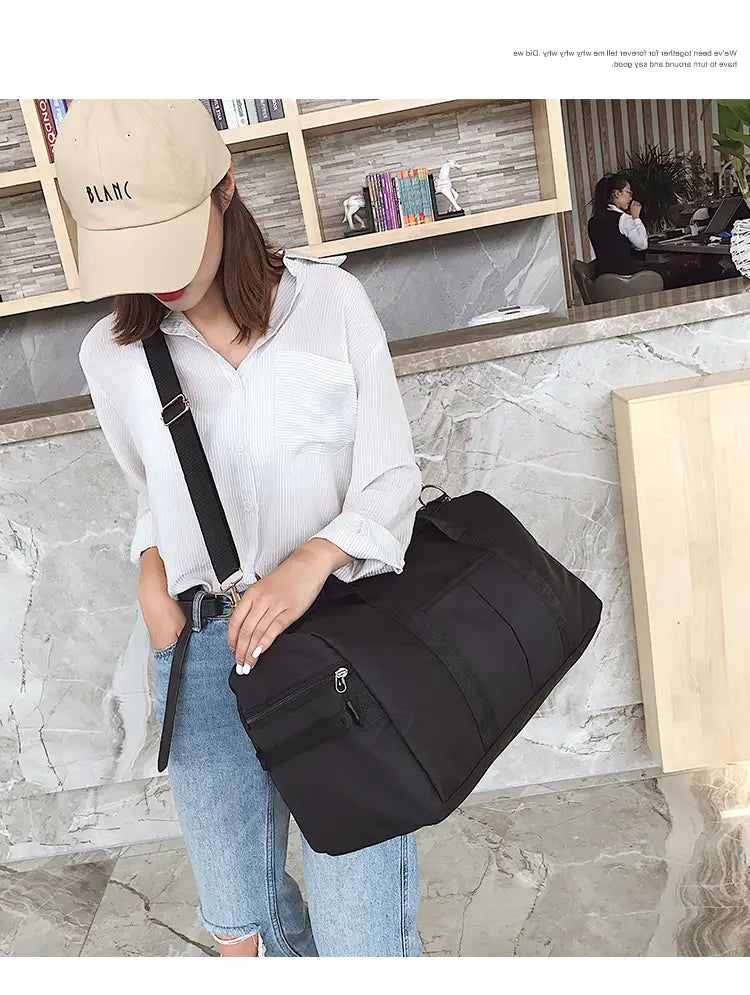 Black nylon sports duffel bag with a single shoulder strap and front zipper pocket from the Rose Gold nylon waterproof collection.