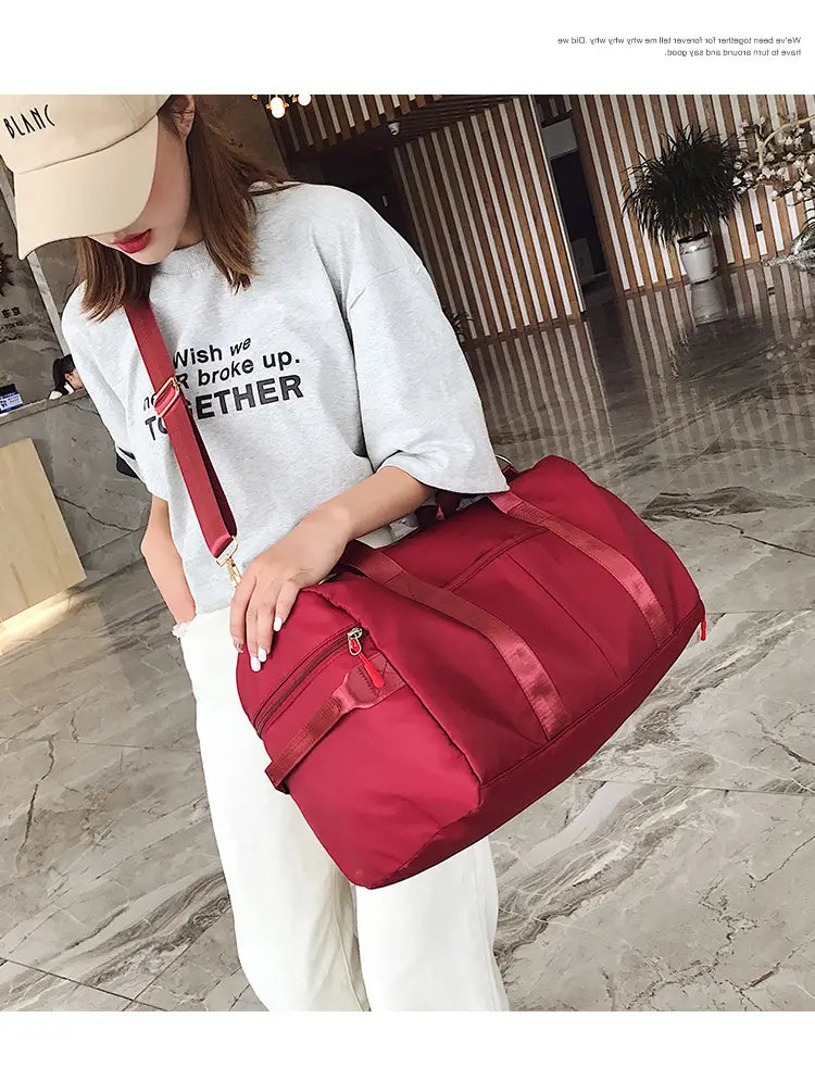 red nylon waterproof sports duffel bag with matching shoulder strap and front zipper pocket