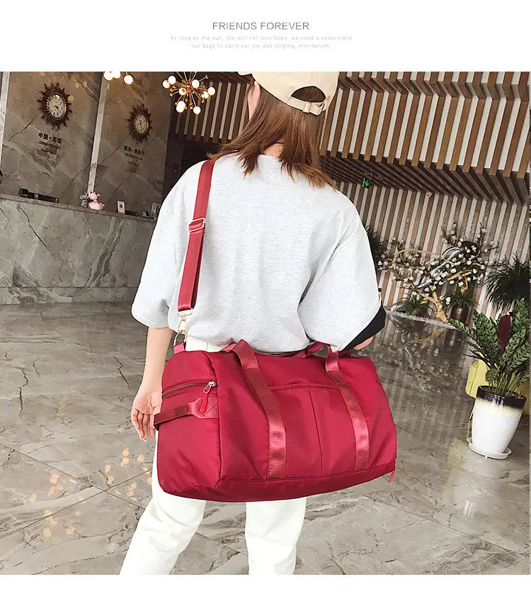 Rose gold nylon waterproof sports duffel bag featuring red nylon material with matching shoulder strap and front zipper pocket.