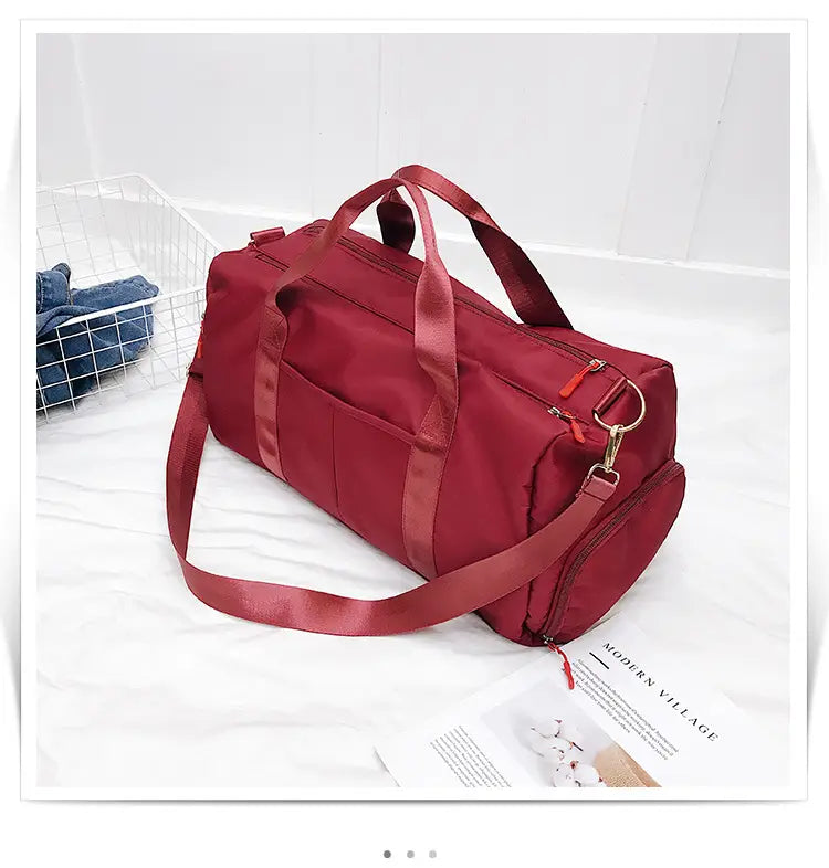 A vibrant red durable nylon waterproof sports duffel bag with matching handles and a detachable shoulder strap.