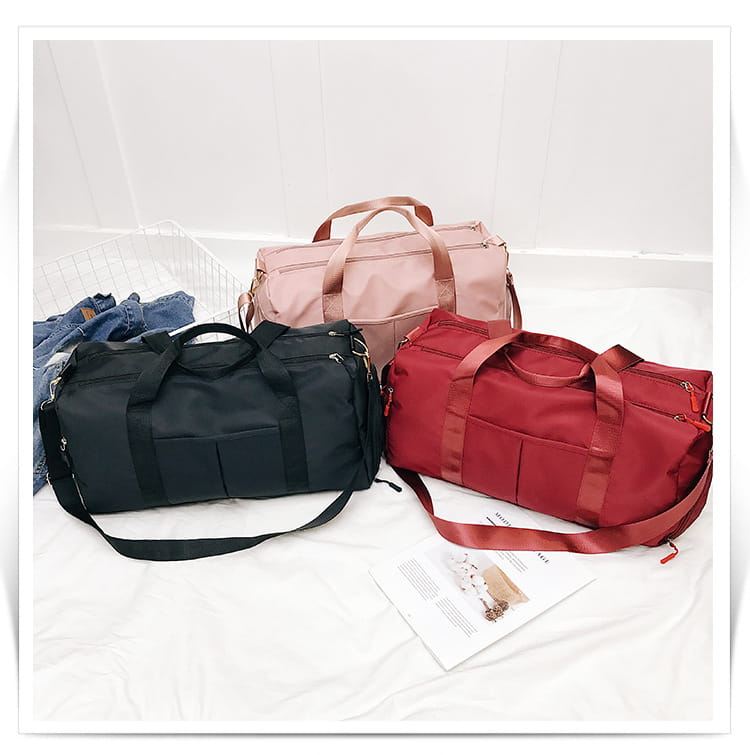 Three waterproof nylon sports duffel bags in black pink and red with fabric handles and adjustable straps.