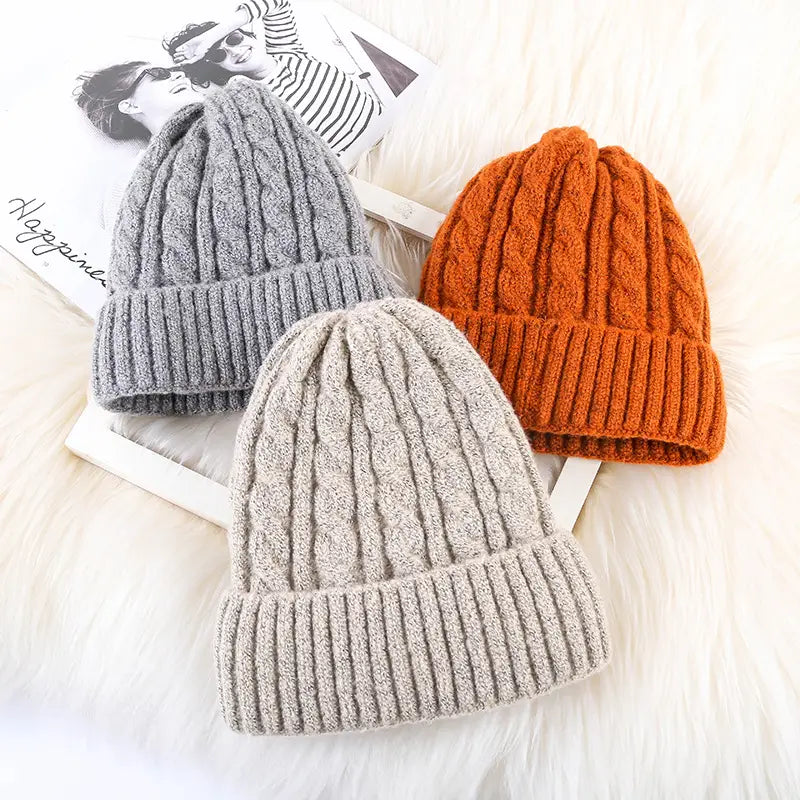 Three fleece lined cable knit beanie hats in gray beige and orange designed for winter warmth
