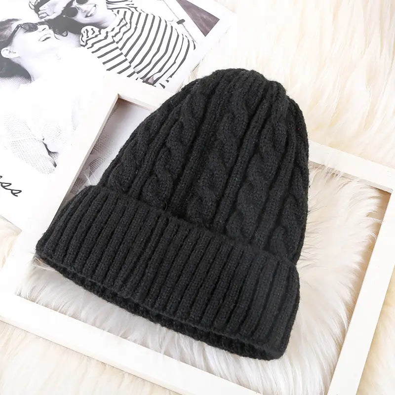 Black cable knit beanie hat with ribbed brim fleece lined for winter warmth.