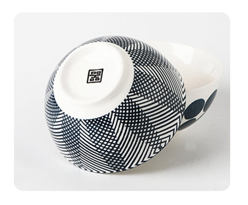 a ceramic bowl from a five-piece japanese floral porcelain set featuring a black and white geometric pattern with intersecting lines forming diamond shapes on its exterior.