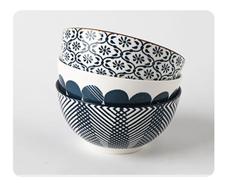 Stacked ceramic bowls from a five piece Japanese floral porcelain set featuring intricate black and white patterns with floral motifs on the top bowl and geometric designs on the bottom.