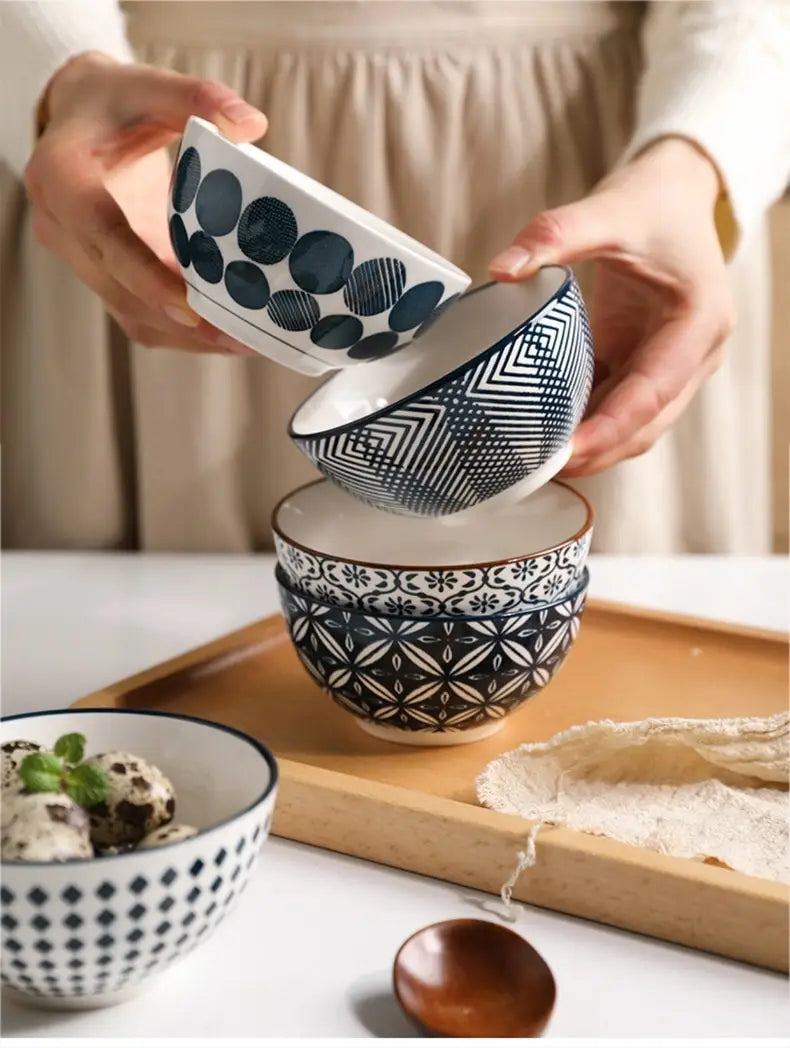 Set of four black and white geometric patterned ceramic bowls stacked on a wooden tray from the ceramic bowl set 5 piece Japanese floral porcelain collection.
