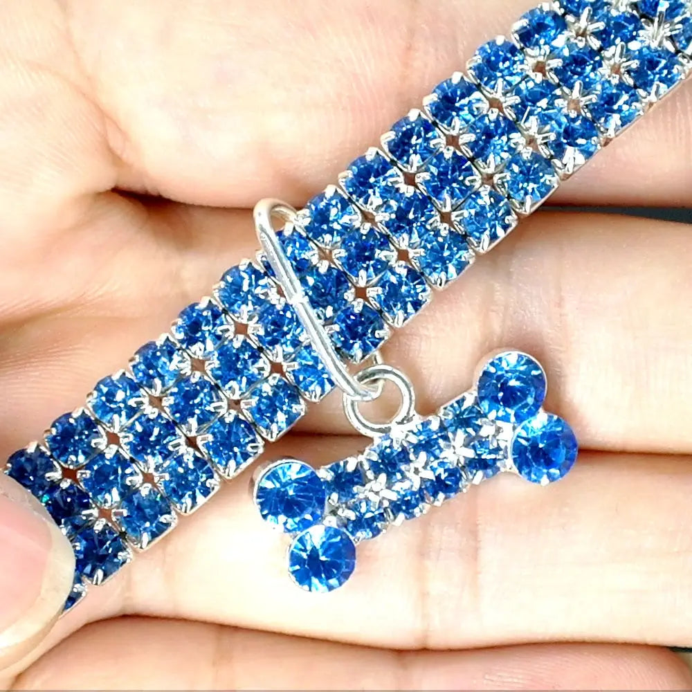 A sparkling blue rhinestone dog collar with a matching crystal bone charm designed for stylish pet accessories.