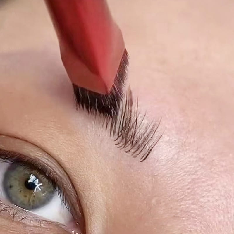 Red wild eyebrow brush with dense dark bristles designed as a 3d stereoscopic makeup tool.