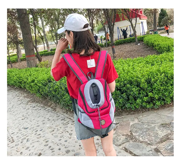 Breathable mesh pet carrier backpack in pink and gray with black straps and a circular logo on the front.