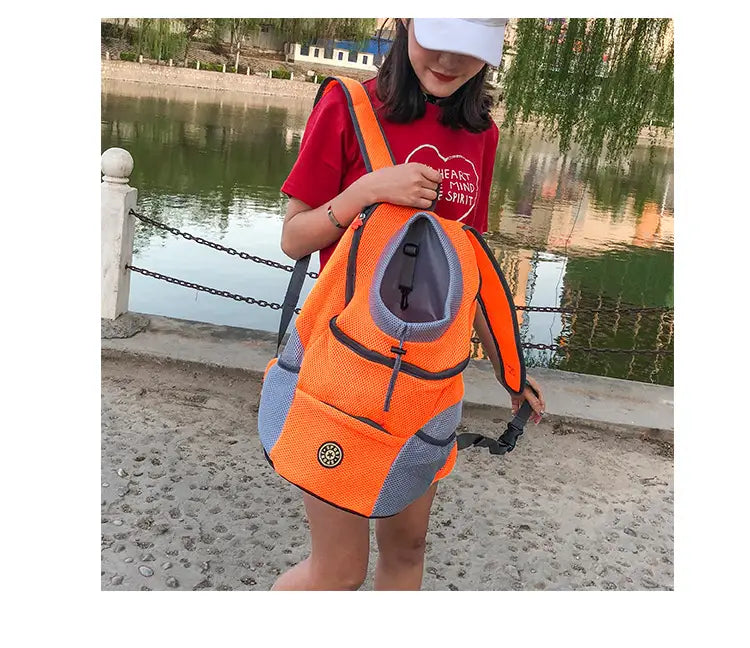 Bright orange and gray breathable mesh pet carrier backpack with adjustable straps and a circular logo on the front.