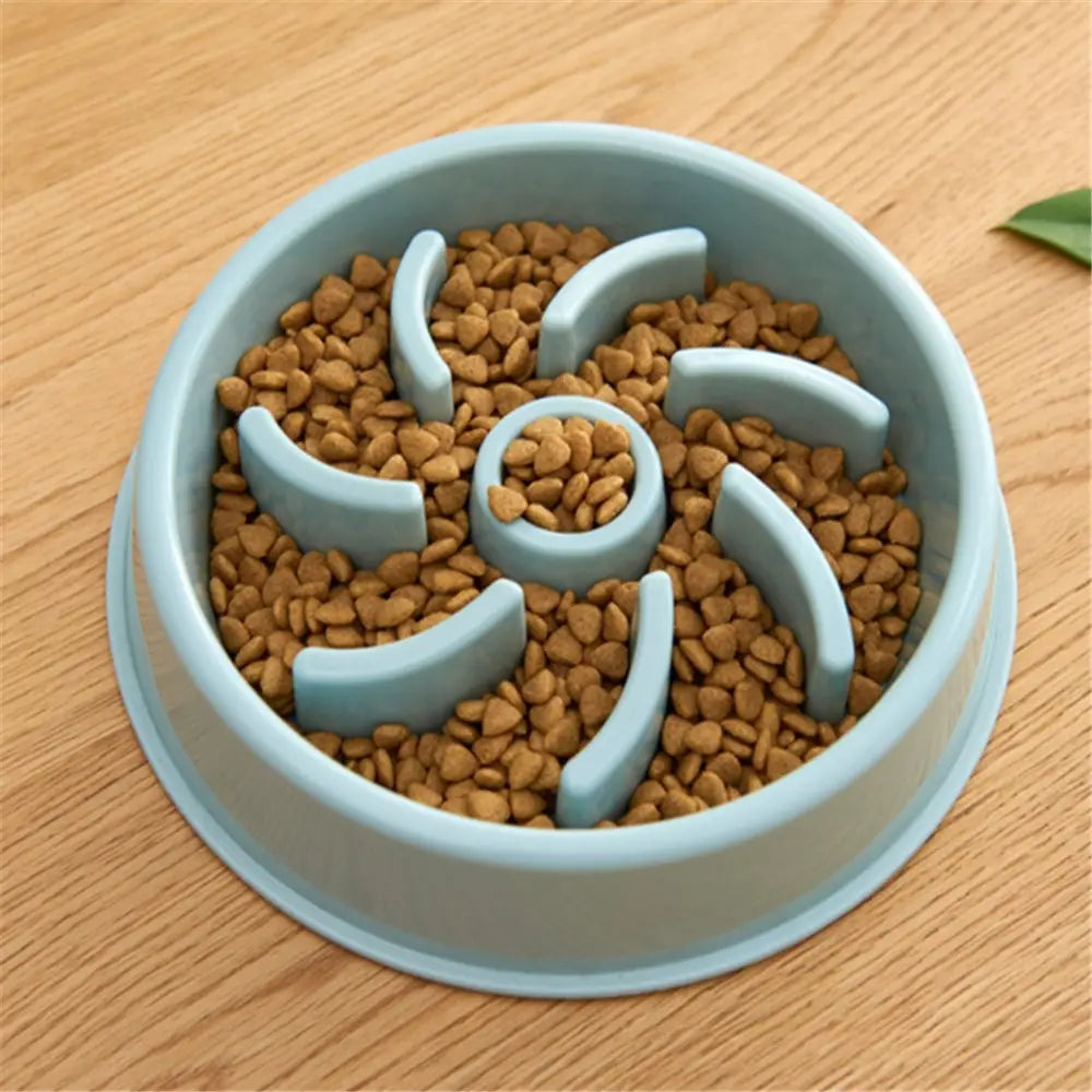 Light blue plastic slow feeder dog bowl with curved dividers and a central circular opening designed as an anti choke pet dish.