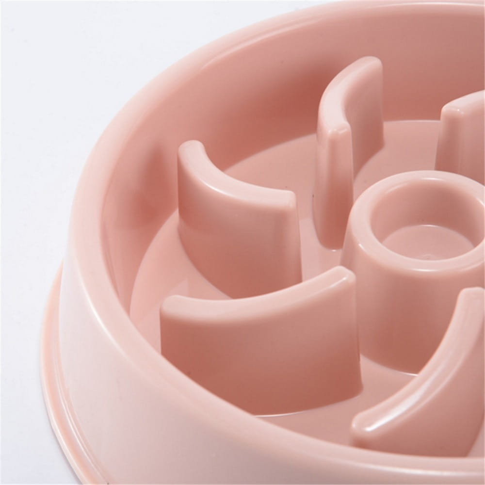 pink plastic slow feeder dog bowl with curved partitions and central hole designed as an anti choke dish for pets