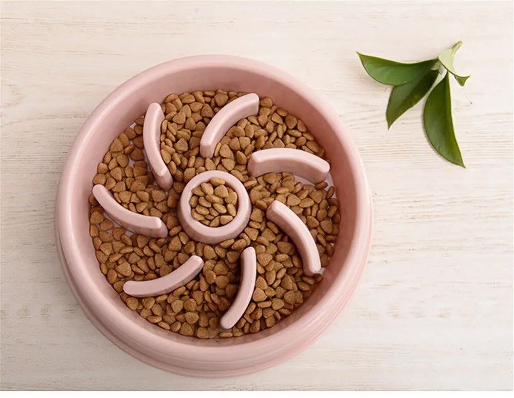Pink silicone slow feeder dog bowl with pet food and leaf garnish designed as a plastic pet anti choke dish