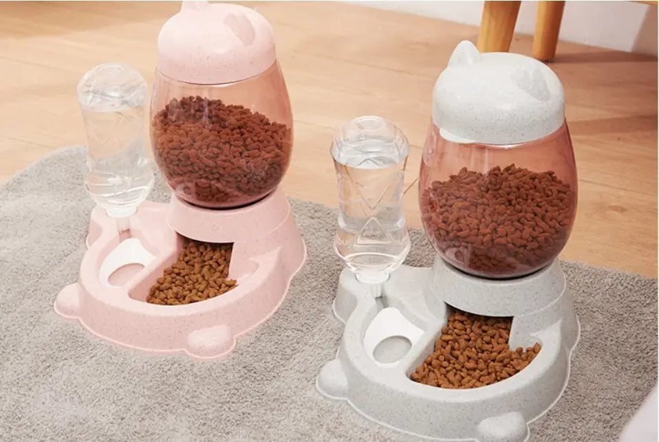 automatic cat feeder gravity pet waterer station in pink and white shaped like a cat with transparent reservoirs filled with brown kibble for convenient pet feeding.