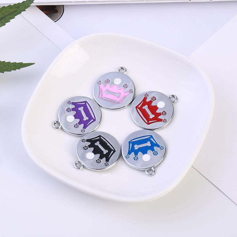 Five circular enamel dog tag charms in pink purple red black and blue featuring crown designs and silver-toned metal edges from the Crown Enamel Pet Id Tag 5 Pack.