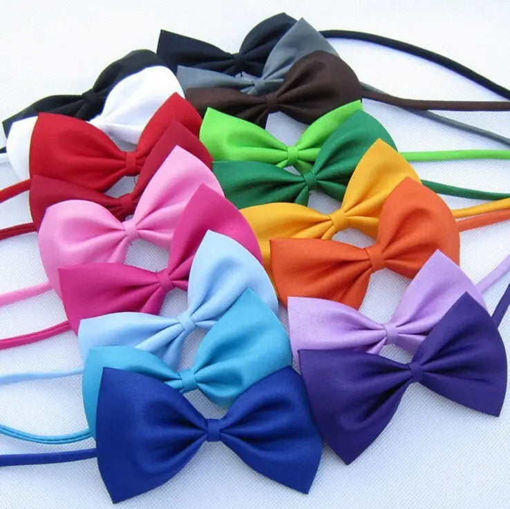 Un conjunto de lazos tipo moño de satén ajustables para perros y gatos en varios colores, incluidos rojo, rosa, verde, amarillo, naranja, azul y morado.