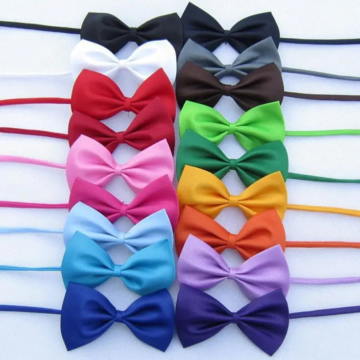 un conjunto de lazos tipo moño de satén ajustables para perros y gatos en varios colores, incluidos negro, blanco, rojo, rosa, azul, verde, amarillo, naranja, morado y marrón
