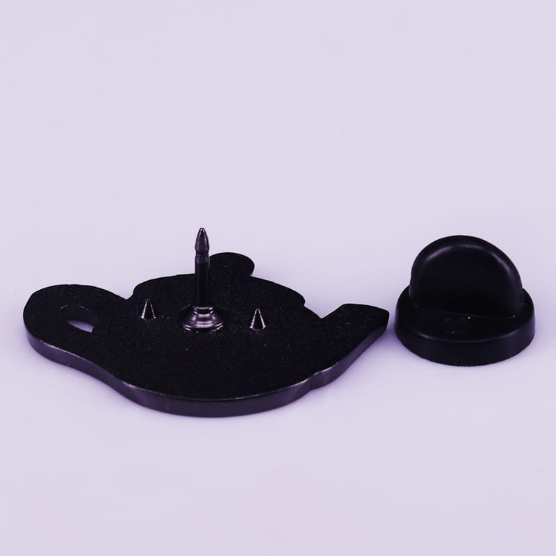 Black teapot-shaped cat witch enamel pin with matte finish and copper metallic clasp mechanism viewed from the back side.