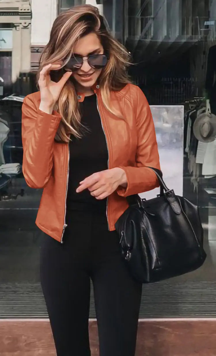 a sleek black leather handbag with a structured shape and top handle shown alongside a faux leather bomber jacket fitted zip up coat